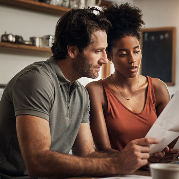 A man and woman sit together at a table and review a document