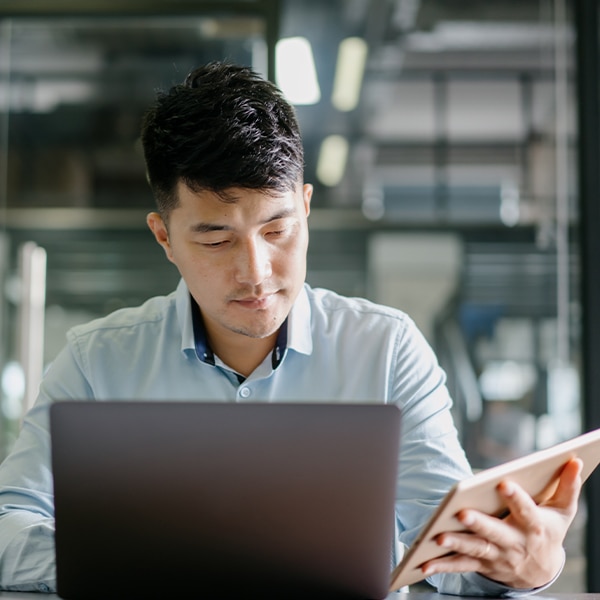 Person working on laptop and tablet