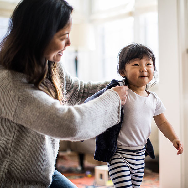 Mother helping child put coat on