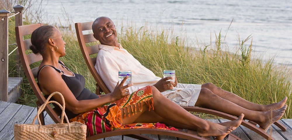 Older man and woman relaxing on the beach.