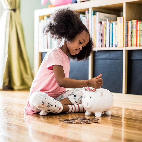 Little girl with piggy bank