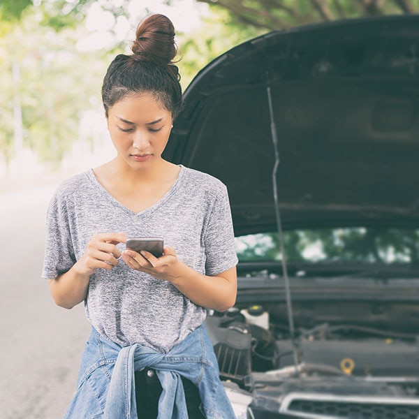 Woman texting for road side service