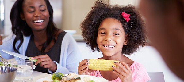 Child eating corn on the cobb.