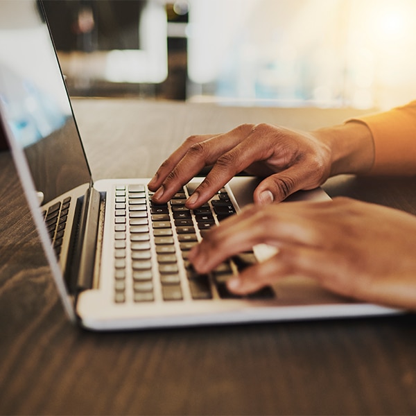 hands tapping on laptop keyboard