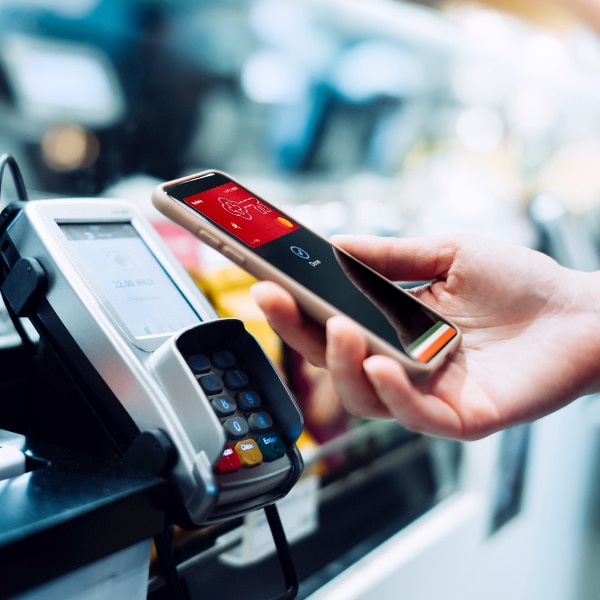 hand holding cell hone over payment processor