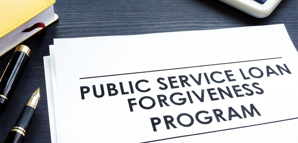 Close‑up of a document labeled ‘Public Service Loan Forgiveness Program’ with a calculator nearby.