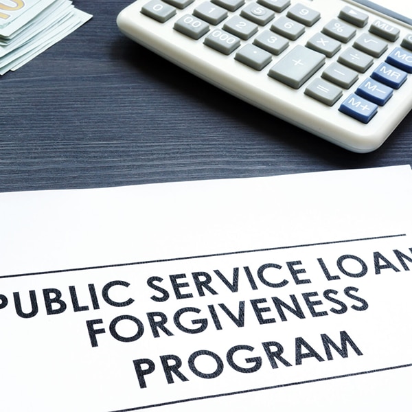 Close‑up of a document labeled ‘Public Service Loan Forgiveness Program’ with a calculator nearby.