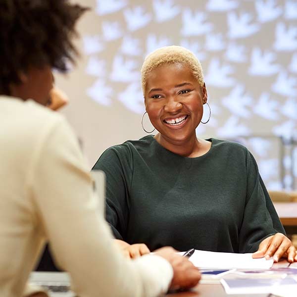 Two people pleasantly reviewing documents.