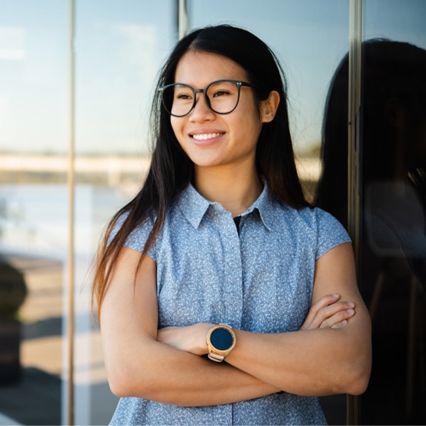 Woman smiling with arms crossed.