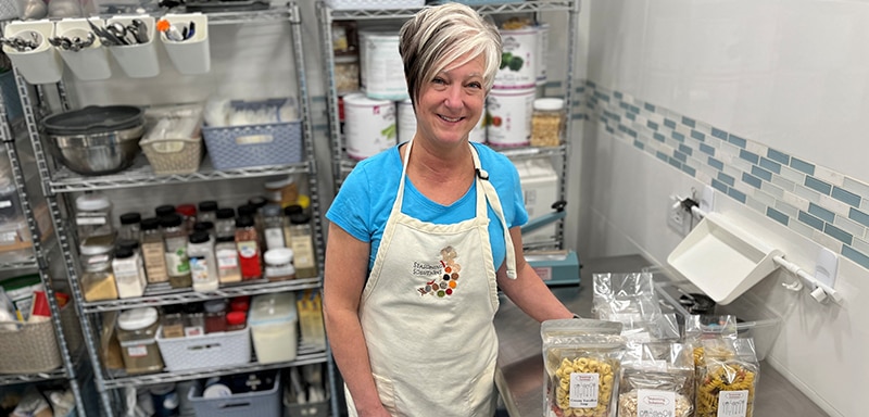 Kitchen with shelves of spices and packaged pasta mixes on counter