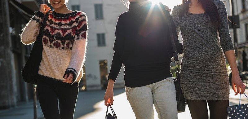 Three young women walking with shopping bags
