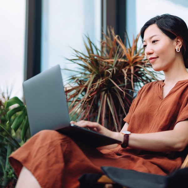 Woman sitting outside typing on laptop