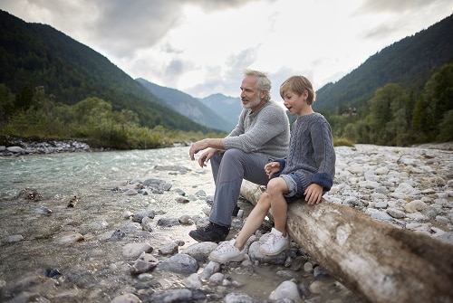 Father and son on river bank
