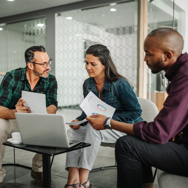 Company employees meeting around laptop